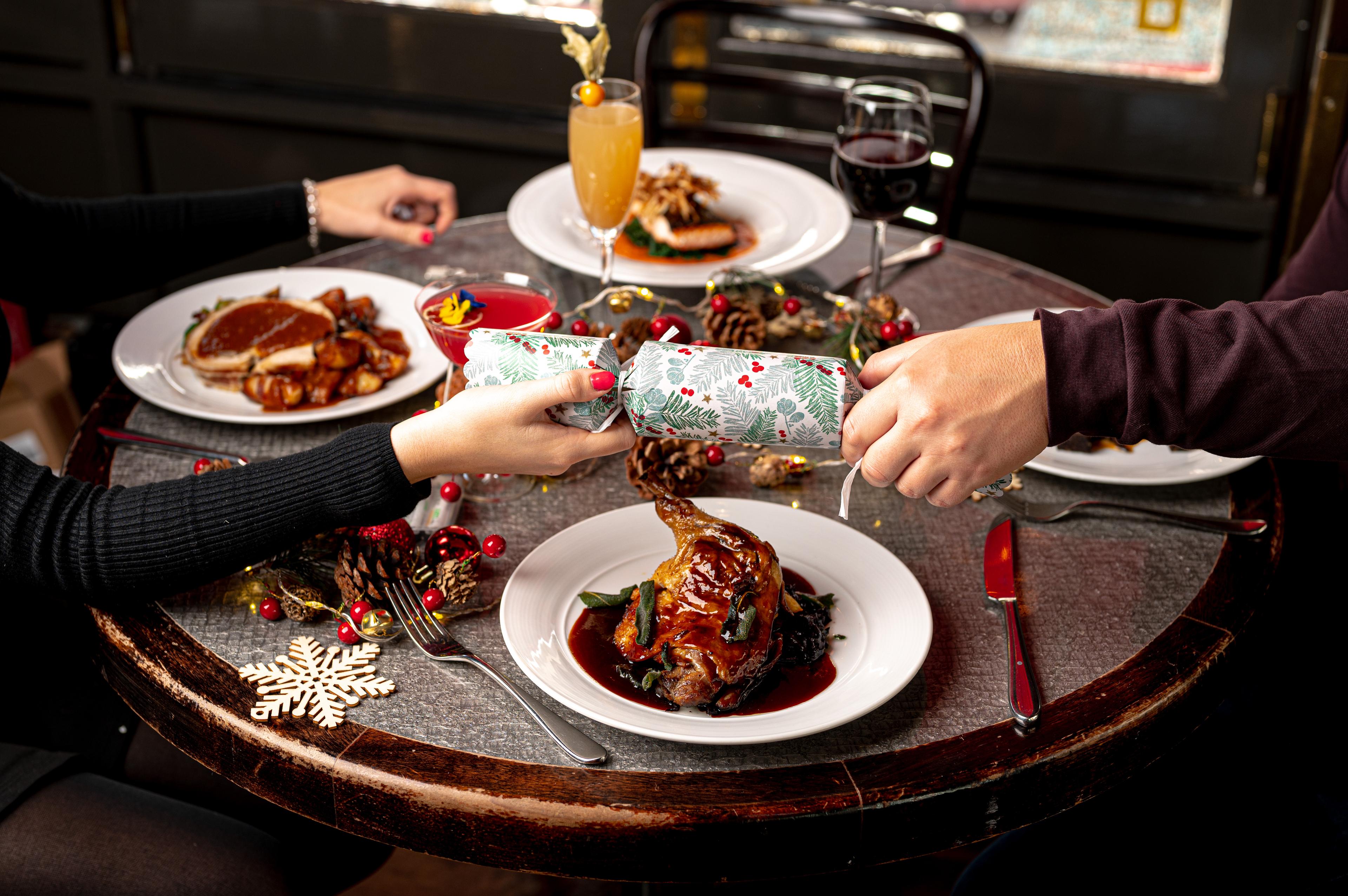 Customers Pulling a Christmas Cracker at Tuttons Restaurant in Covent Garden